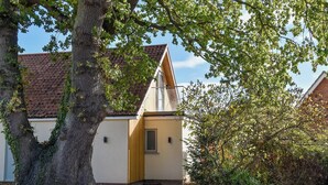 A building with a sloped roof, a small window, and a door. - 2 bedroom accommodation in West Mersea (West Mersea)