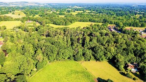 An aerial view of a rural landscape with rolling green fields, scattered trees, and a few buildings. - 1 bedroom accommodation in Woolton Hill, nr Newbury (Woolton Hill, nr Newbury)