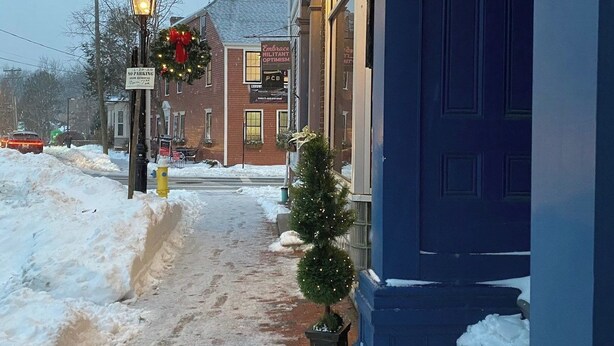 A snow-covered street with a building featuring a 'Hello Lovely' sign. - Townhouse Apt 2 w Parking in Downtown Portsmouth (Portsmouth)