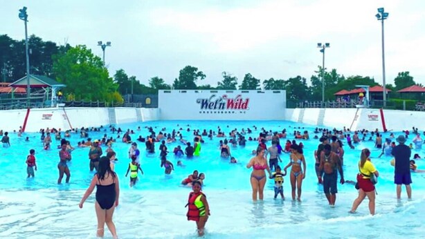 Suuri sisäuima-allas, jonka yläpuolella on kyltti, jossa lukee ”Wet n Wild”, ja jonka ympärillä on yleisöä.