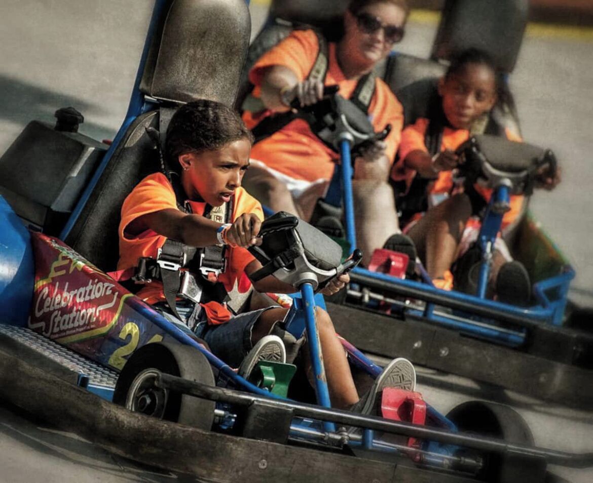 A go-kart track with participants in orange uniforms.