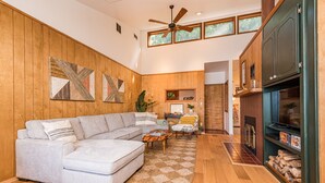 A living room with a sectional sofa, a coffee table, and a fireplace. - Private Waterfront Spa Retreat + Movie Theater (Port Townsend)