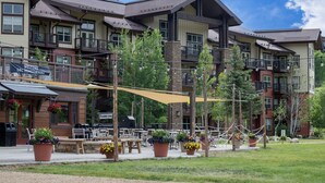 A multi-story building with balconies, outdoor seating, and potted plants. - Granby Ranch Haven: Outdoor Pool & Biking Fun (Granby)