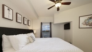 A bedroom with a large bed, a ceiling fan, and framed artwork on the walls. - Granby Ranch Haven: Outdoor Pool & Biking Fun (Granby)