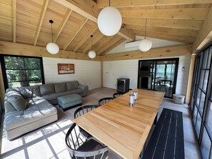 A wooden interior with a sofa, ottoman, dining table, and chairs. - FOX HILL All season retreat at Star Lake, Whiteshell with dock  (Star Lake)