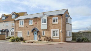 A two-story residential building with a brick facade, multiple windows, and a front door. - 3 bedroom accommodation in Beadnell (Beadnell)