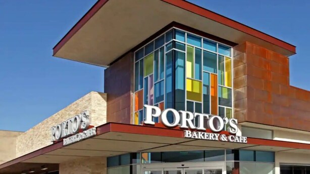 Un edificio con un letrero que dice "PORTO'S BAKERY & CAFE" y una entrada de vidrio.