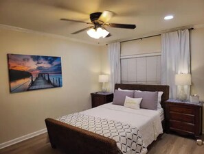 Cozy retreat with a large bed, two nightstands, and a ceiling fan, offering a peaceful atmosphere.
