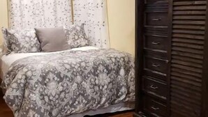 Une chambre à coucher comprenant un lit, une armoire et un appareil de climatisation.