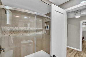A modern bathroom with a glass-enclosed shower, a white sink, and a vanity. - Beach Home-Rooftop Deck-Steps to Sand (Oxnard)