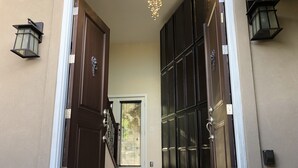 A modern entrance with a glass door, a metal staircase, and two wall-mounted lanterns. - Lookout Mountain Lodge & Chalet with Views! (30 Day Min) (Golden)