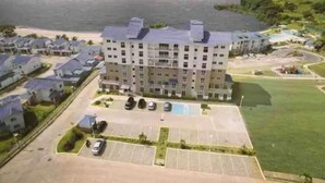 Un hotel a più piani con parcheggio e vista sul mare.