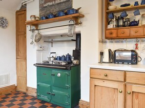 A vintage kitchen with a green stove, wooden cabinets, and a tiled floor. - 4 bedroom accommodation in Kirkby Lonsdale (Kirkby Lonsdale)