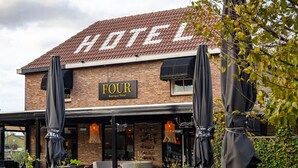 A hotel named 'Four Boutique Hotel' with outdoor seating and umbrellas. - Boutique Hotel Four (Geldrop)