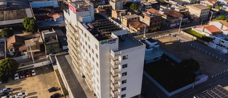 Un hôtel à plusieurs étages doté d’une terrasse sur le toit et d’un parking.