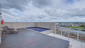 Un área de piscina en la azotea con vistas a la ciudad.