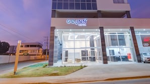 Un hotel GOJNN con fachada de vidrio moderna y un letrero destacado.