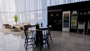 Un interior moderno con comedor, sofás y una zona de bar con refrigerador.