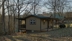 A two-story house with a balcony, a porch, and a covered outdoor seating area. - Cozy Waterfront Escape near Helen & Vineyards (Cleveland)