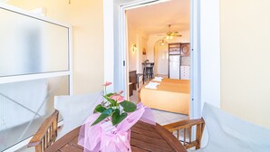 Ein Balkon mit einem Holztisch, einem Stuhl und einem Blumentopf.