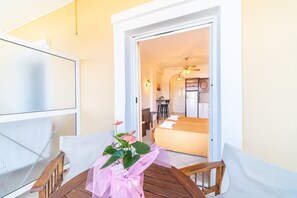 A balcony with a wooden table, a chair, and a potted plant. - Studio Apartment "Mazis Studio A" with Sea View, Balcony & Wi-Fi (Corfu)