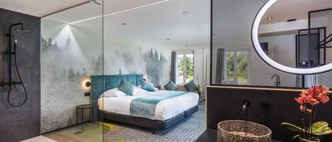 Un dormitorio moderno con una cama grande, cabina de ducha de vidrio y un espejo redondo.