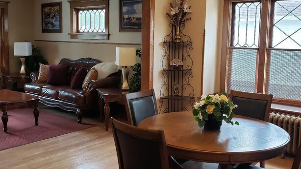A cozy living room with a fireplace, a dining table with chairs, and a chandelier. - Charming unique historical home on Main street, in the heart of Downtown Bozeman (Bozeman)