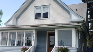 A two-story house with a front porch, a number '512' on the door, and potted plants on the steps. - Charming unique historical home on Main street, in the heart of Downtown Bozeman (Bozeman)