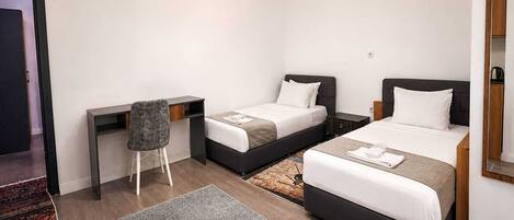 Una habitación de hotel con dos camas, un escritorio y una silla.