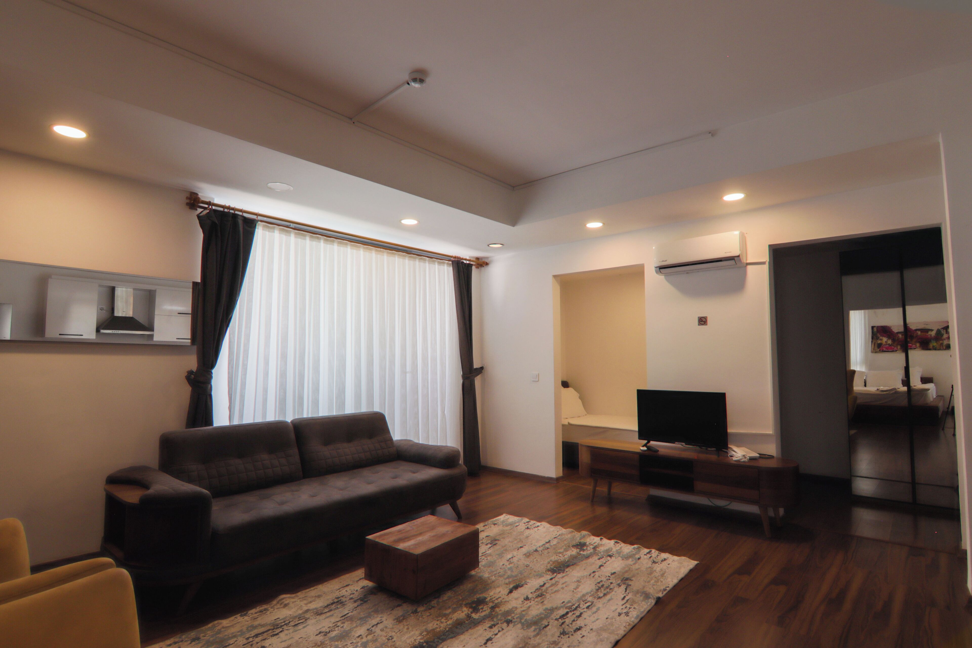 A modern living room with a sofa, a coffee table, and a TV.
