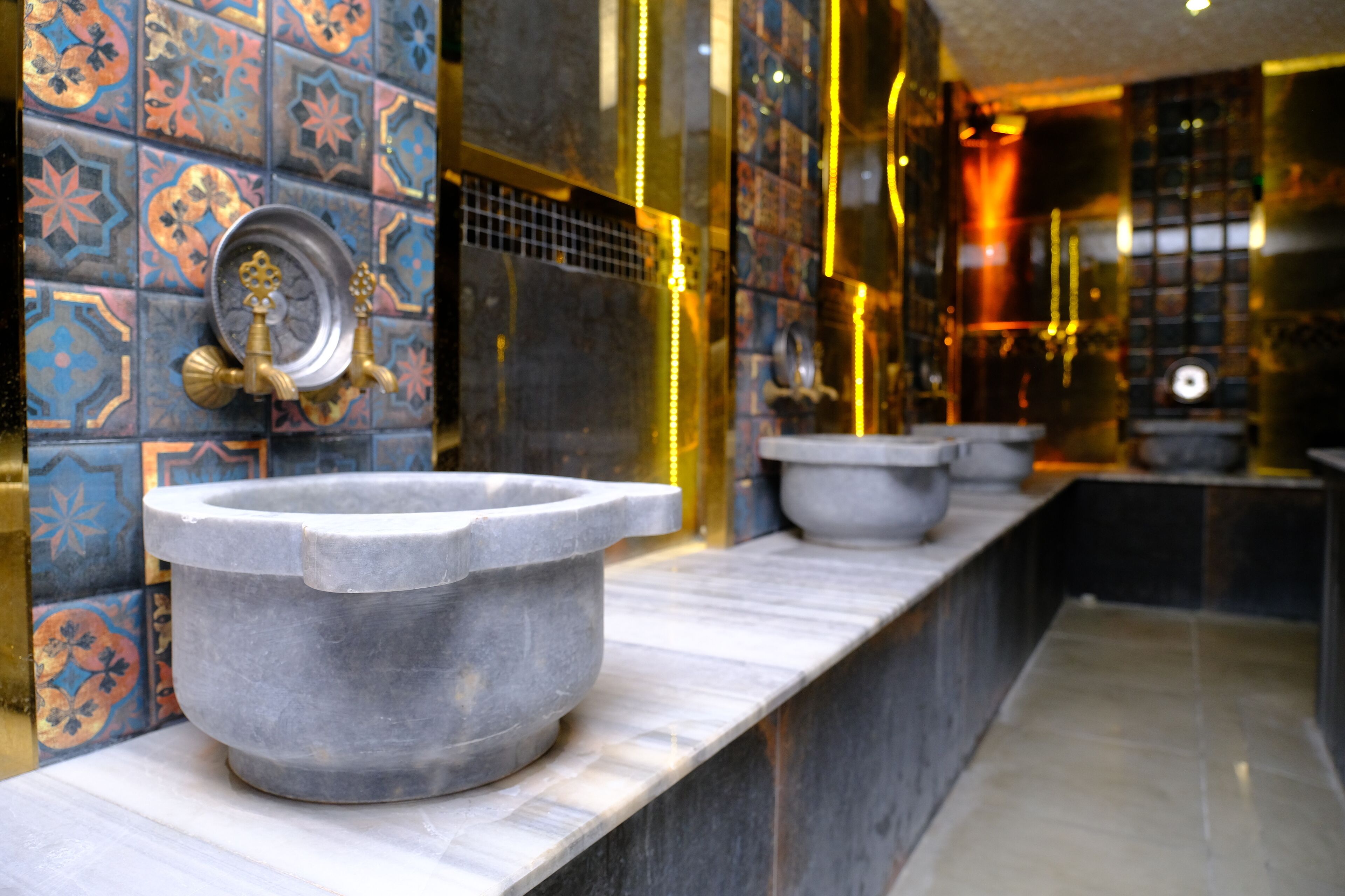 Un baño con lavabo de piedra, paredes con azulejos y un diseño moderno.
