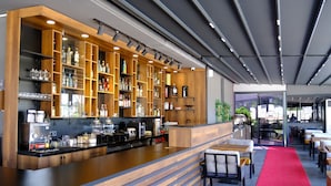 A modern bar area with wooden shelves, a counter, and seating. - Side Mira Palace (Manavgat)