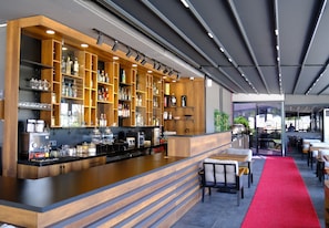 A modern bar area with wooden shelves, a counter, and seating. - Side Mira Palace (Side)