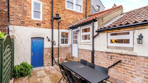 A brick building with a blue door, a white window, and a tiled roof. - This property is completely unique. (Scarborough)