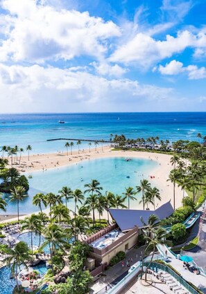 A resort with a large pool, beach, and ocean view.