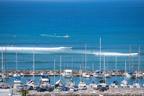 A marina with boats docked and a rocky breakwater. - 1016 · Ilikai Collection # 4. Amazing views, beachfront. (Honolulu)