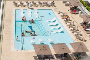 A swimming pool with multiple lanes, sun loungers, and umbrellas. - 1016 · Ilikai Collection # 4. Amazing views, beachfront. (Honolulu)