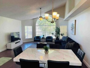 Relax in this stylish living area with a large dining table, comfortable sofa, and flat-screen TV.