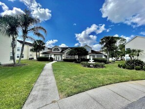 Stroll through the beautifully manicured lawn to the single-story house with a gabled roof and inviting front porch.