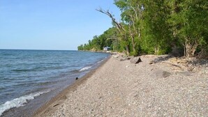 A pebbled beach with trees and a clear sky. - Island Sandbar retreat with sunset views, water toys and more! Boat-Only Access (Wolcott)