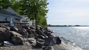 A house by a rocky shoreline with a view of the water. - Island Sandbar retreat with sunset views, water toys and more! Boat-Only Access (Wolcott)