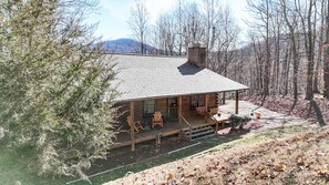 A log cabin with a porch, wooden chairs, and a fireplace. - Unwind in Seclusion: Log Cabin Retreat with Wood Burning Stove & Game Table (Shipman)