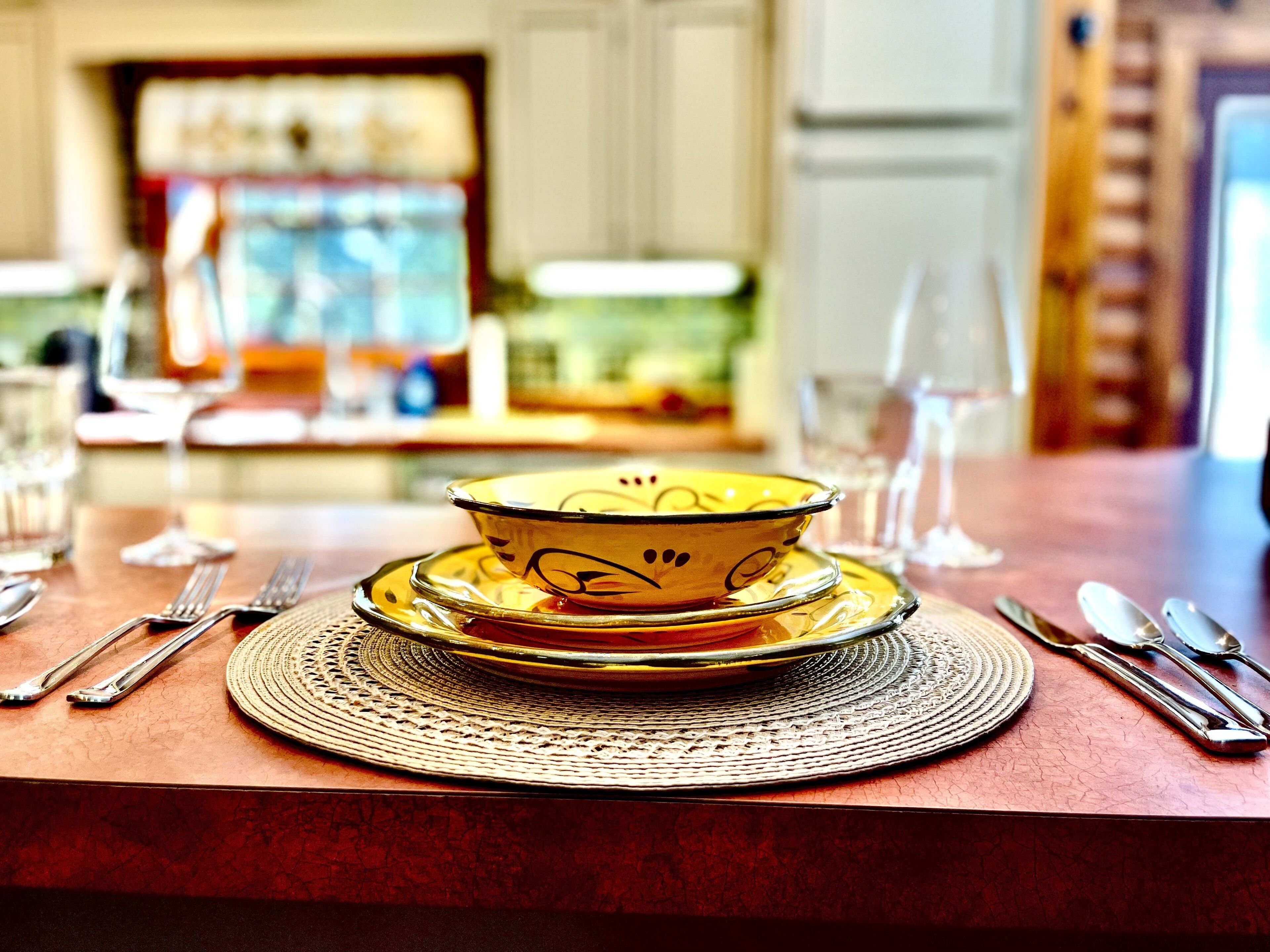 Plates, bowls, wine glasses, utensils, and in the fully equipped kitchen.