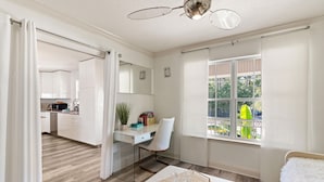 A modern, well-lit room with a large window, a dining area, and a view of the outside. - Golden Isles Getaway -**ASK ABOUT SNOWBIRD SPECIALS** (Brunswick)