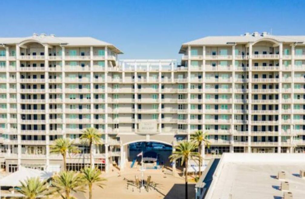 A large, multi-story hotel with a symmetrical facade, numerous balconies, and a central entrance.