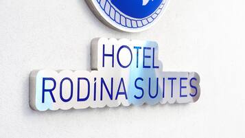 A hotel sign with a globe and the letters 'R' and 'D' in red, indicating the name 'Hotel Rodina Suites'.