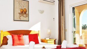 A hotel room with a bed, red and white bedding, a nightstand, a lamp, and a painting on the wall. - Traditional villa with BBQ and heatable pool (Albufeira)