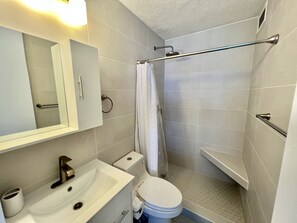 Ein Badezimmer mit Waschbecken, Toilette und Duschbereich.