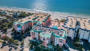 An aerial view of a hotel with multiple buildings, a beach, and a parking area. - 🌴HEATED POOL AND JACUZZI FOR YEAR ROUND RELAXATION ON OCEAN FRONT BEACH⛱️ 
 (Indian Shores)