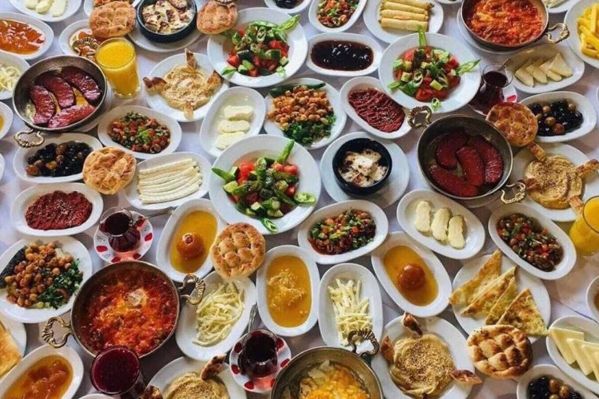 A table filled with a variety of dishes, including salads, meats, and breads.